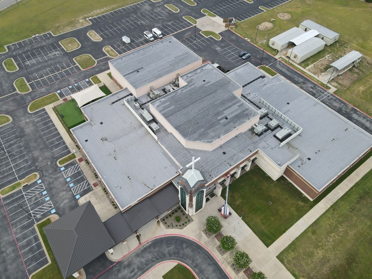 Aerial view of a finished membrane and standing-seam roof on a church campus