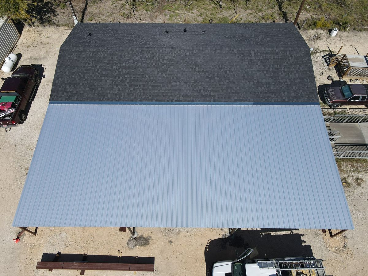 Aerial view of a finished shingle and standing-seam metal roof on a commercial building