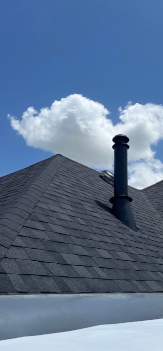 Close roof detail with a vent stack against the sky