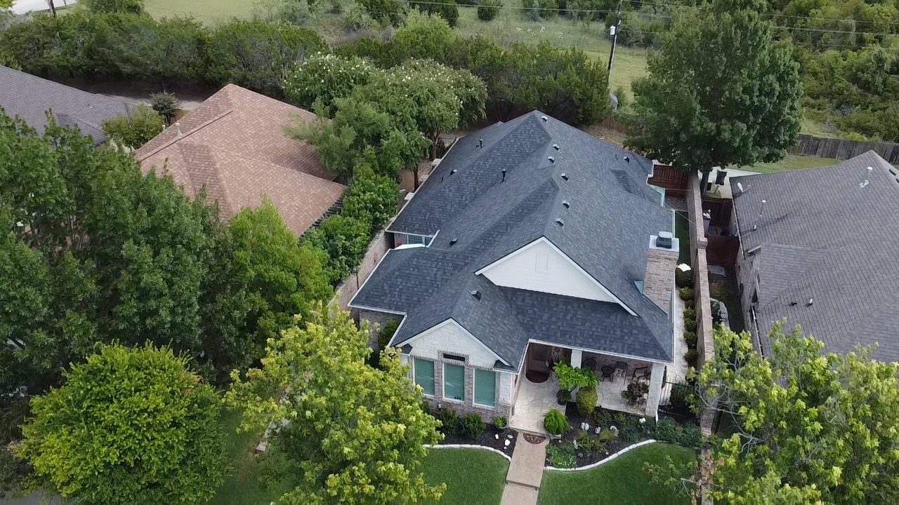 A roof viewed in relation to the complete home and landscape